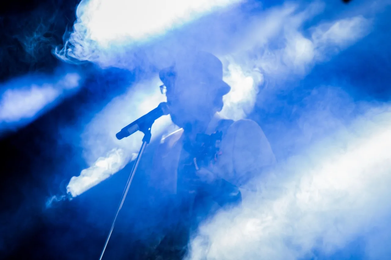 Singer at a microphone in the spotlight Singer at a microphone in the spotlight