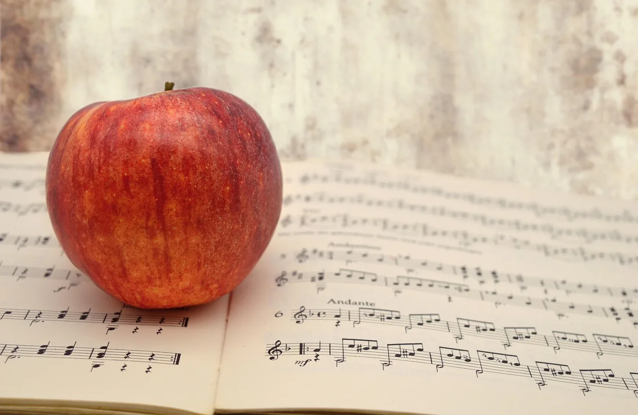 Pomme posée sur une partition musicale Pomme posée sur une partition musicale