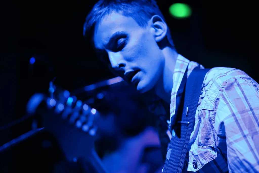 Guitarist performing under blue light